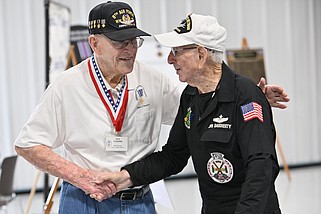 Dub Toombs (left), a World War II veteran, shakes hands with Jim Daugherty, a Vietnam War veteran, during the Distinguished Flying Cross Society’s Gen. Ira Eaker Chapter’s annual picnic at the North Little Rock Airport on Saturday, May 4, 2024. The chapter also celebrated Toombs’ 100th birthday during the picnic. (Arkansas Democrat-Gazette/Staci Vandagriff)